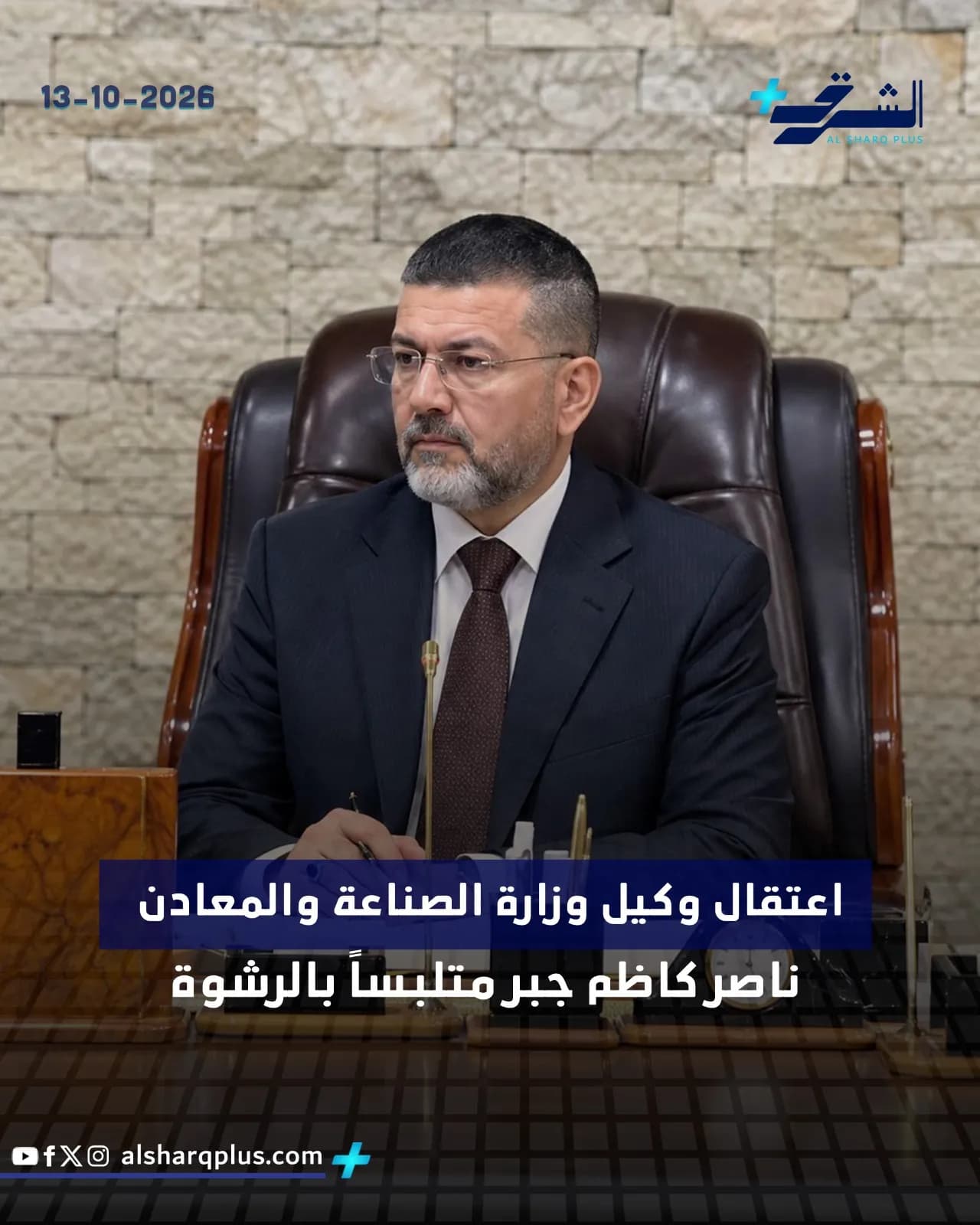 رجل يرتدي بدلة داكنة وربطة عنق بنية يجلس في مكتب، مع نص عربي على الشاشة يشير إلى تاريخ وعلامة تجارية.